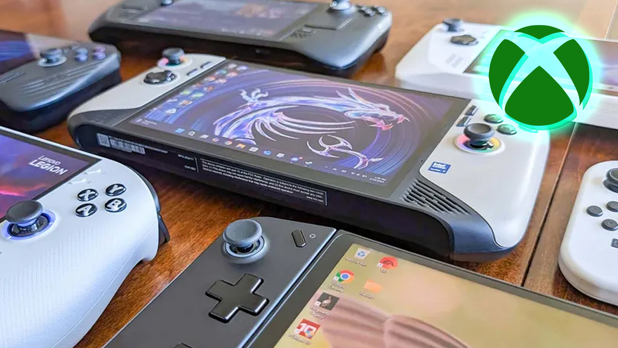 Several Windows handheld gaming PCs laying down on a table. An Xbox logo is in the upper right corner of the image. 