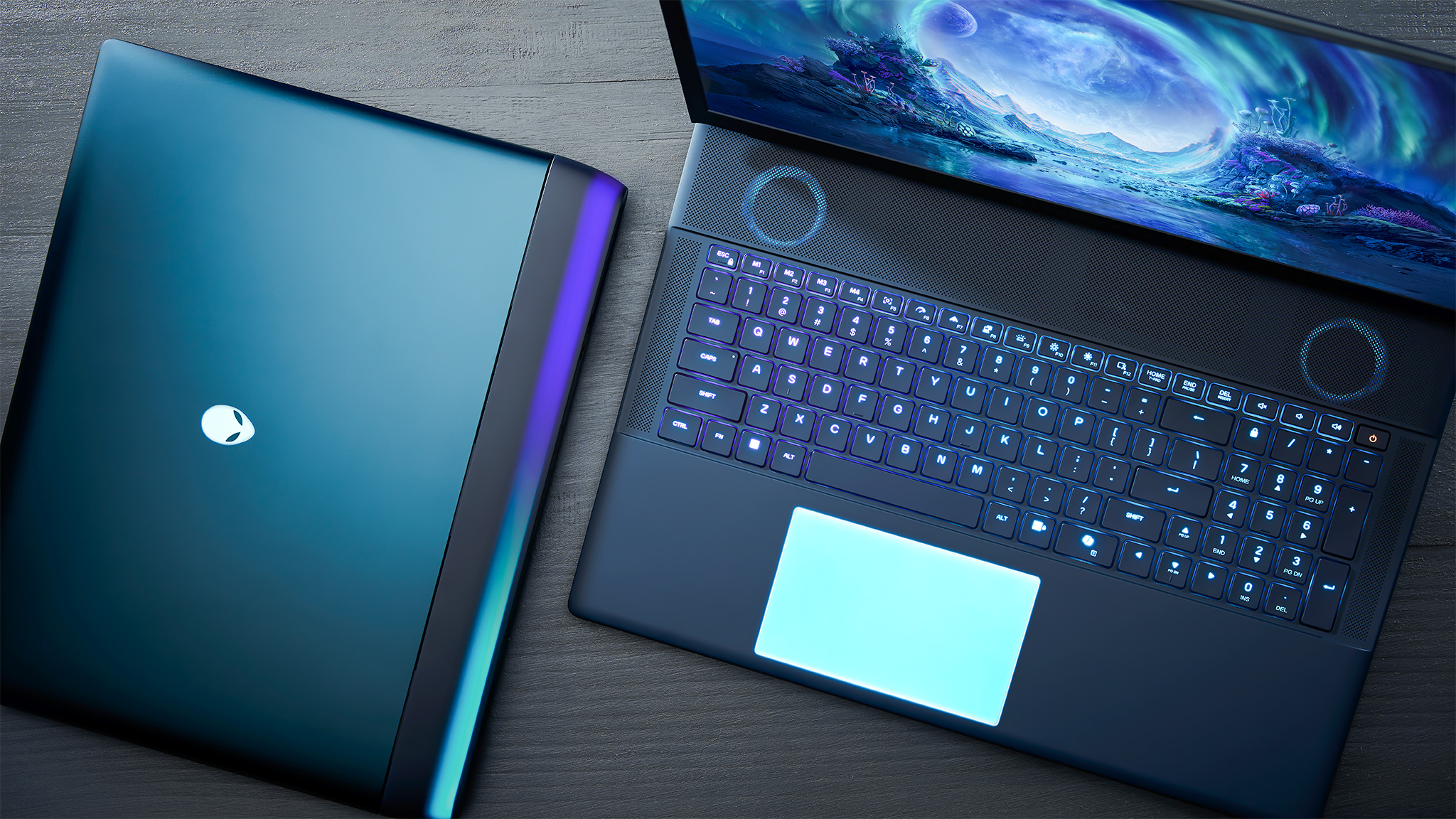 A top down view of two Alienware Area-51 gaming laptops, one closed, one open. 